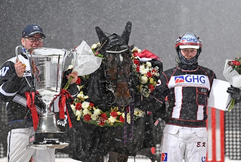 Anders Wolden med gigantpokalen, King Okay med krans og kusk Erlend Rennesvik med seierssmil etter seieren i Sylvesterloppet.
 Foto: TR Bild.